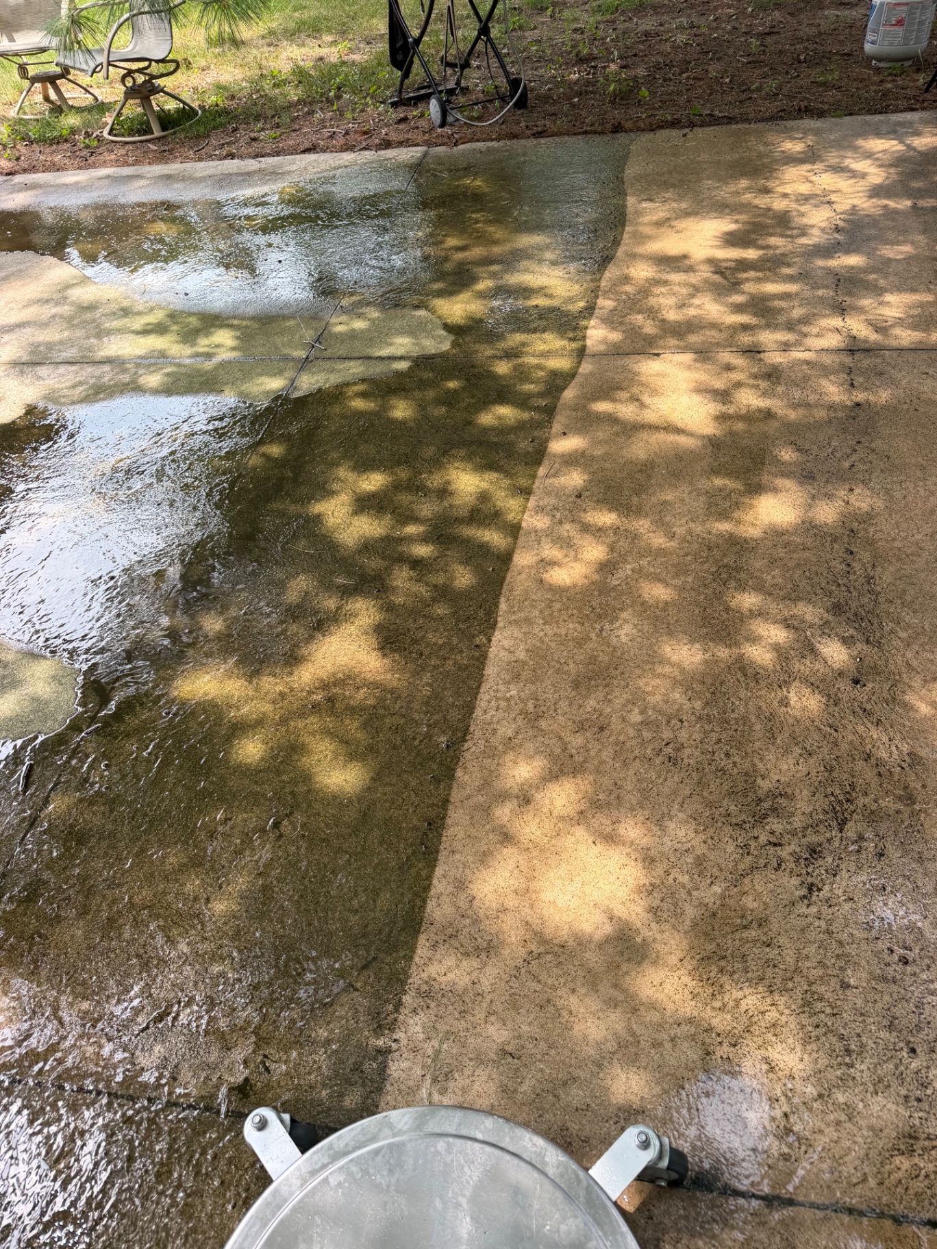 Concrete surface cleaning in progress with a clear line between cleaned and dirty areas