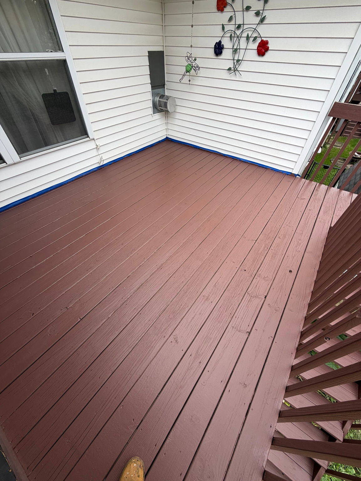 Freshly stained and painted brown deck by Spotless Wash