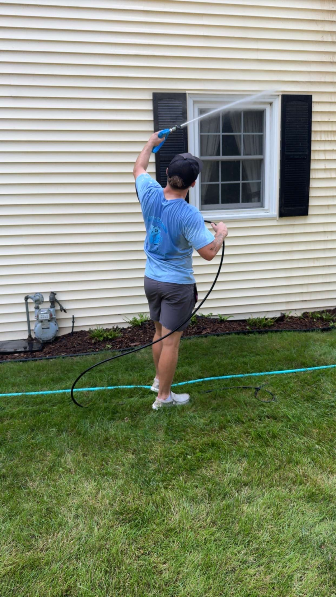 Spotless Wash technician soft washing a house