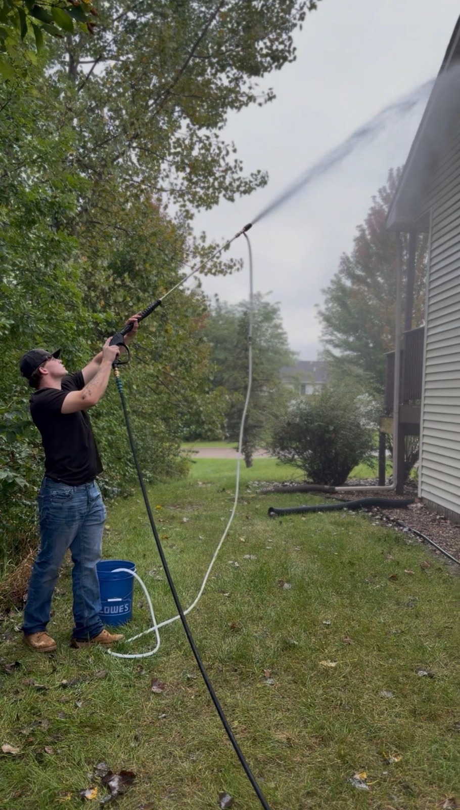 Spotless Wash technician soft washing upper house siding