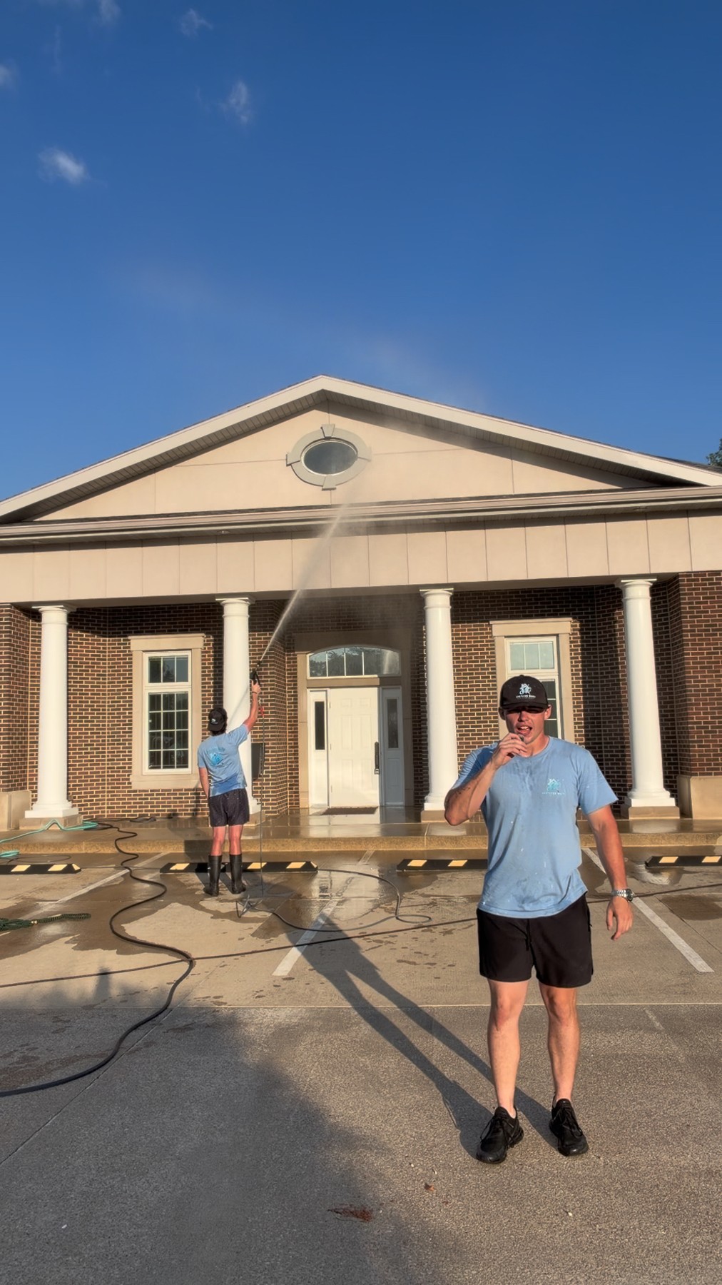 Spotless Wash team washing the exterior of a brick commercial building
